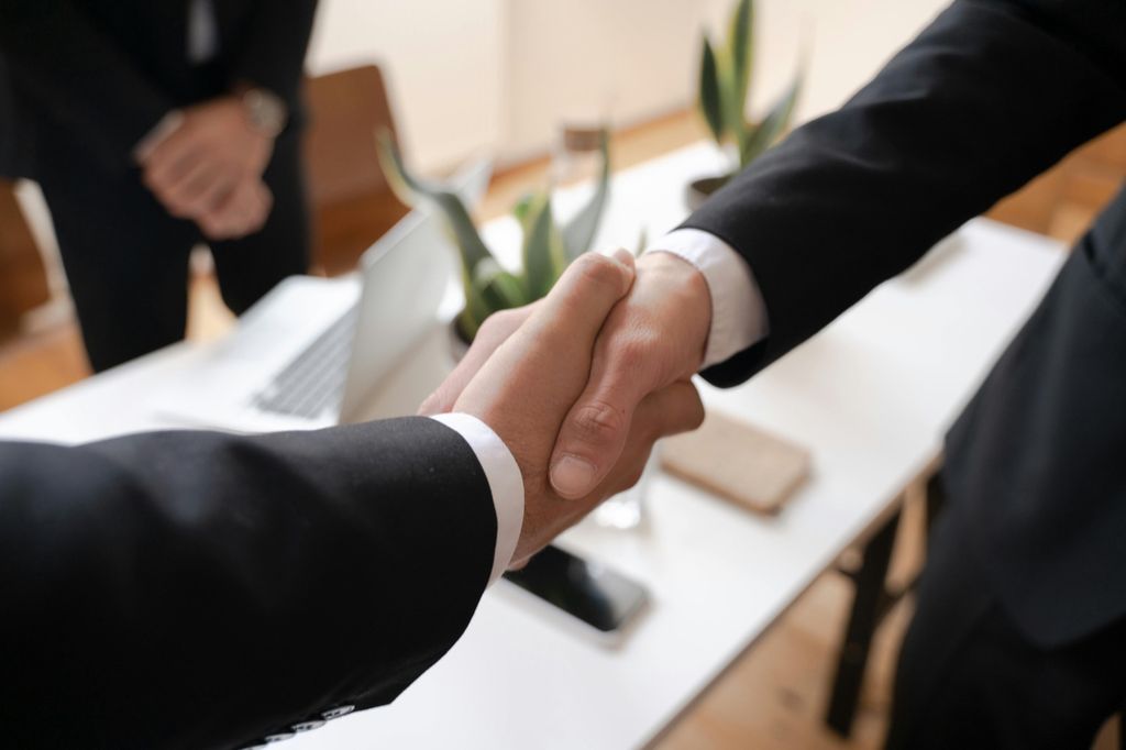 Two people shaking hands after reaching an agreement