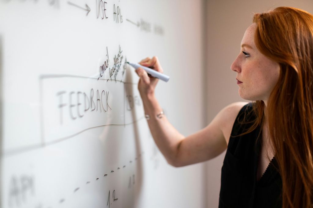 Woman writing on whiteboard during a planning session