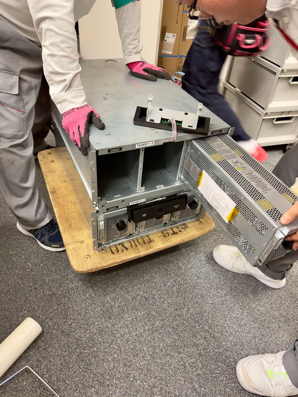 UPSのバッテリーモジュールを取り外す作業員