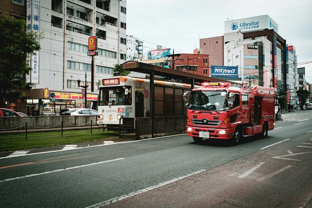 日中の道路を走る赤と白のバス