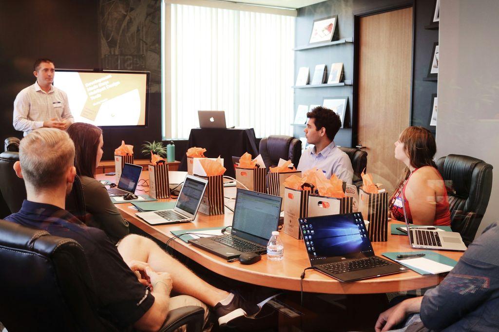 Team gathered around laptops during a business training presentation
